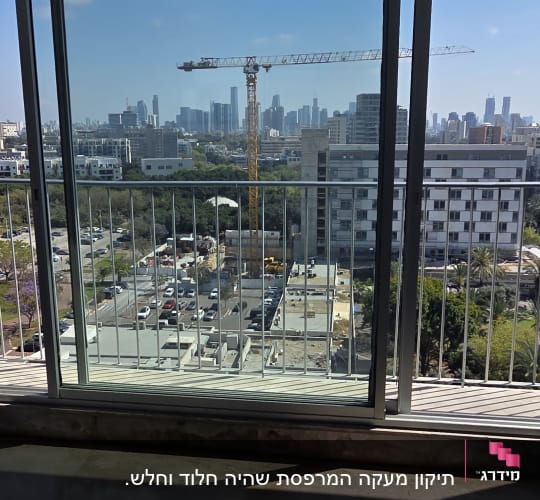 נוף עירוני מבעד לחלון עם מסגרת מתכת